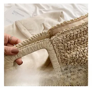 Detailed close-up of compact woven straw texture and secure zipper closure of the tote