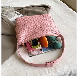 Pink woven hobo bag interior view showing daily items like phone and sunglasses