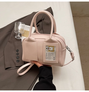 Close-up of light pink leather tote bag featuring a decorative card slot and silver hardware