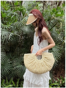 Detail of hand-woven straw beach bag and matching sun hat with pearl embellishments