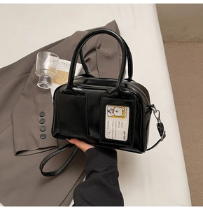 Detail of black glossy faux leather tote bag with card slot and stylish shoulder strap