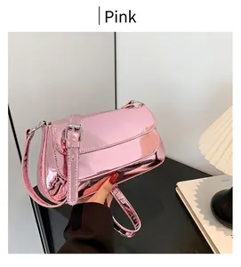 Close-up of pink glossy mirror-finish shoulder bag with metallic synthetic leather texture