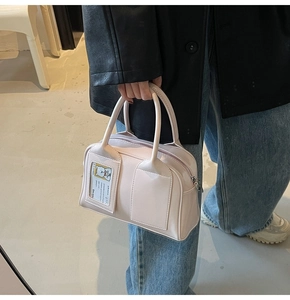 Close-up of light pink pillow handbag featuring a unique transparent bear card slot detail