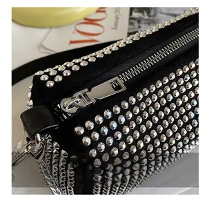 Macro shot of silver metal zipper and dense round stud details on a black suede bag