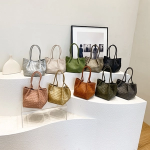 French style woven tote bags in ten colors displayed on a minimalist white gallery stand