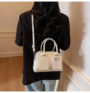 Detail view of cream leather tote bag with card slot showing a cute bear design