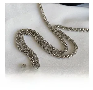 Macro view of high-density silver metal woven chain strap with polished texture