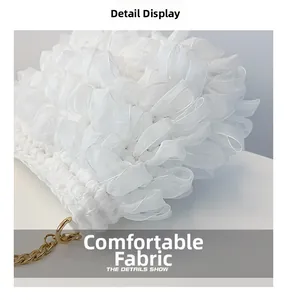 Detailed macro view of white pleated fabric texture with elegant gold metal chain