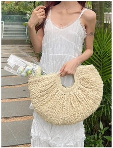 Close-up of beige woven straw tote bag with wave texture and natural round handles