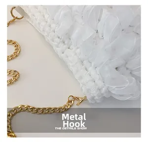 Detail shot of the golden metal hooks and mesh ruffled fabric on a white crossbody bag