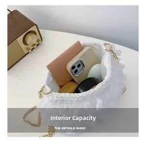 Detailed interior of a white ruffled crossbody bag showing capacity for phone and wallet