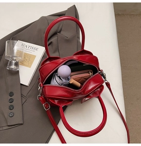 Interior storage view of red patent leather tote bag with umbrella and wallet