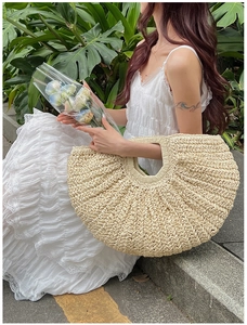 Detail of hand-woven straw handbag with semi-circular design for summer vacations