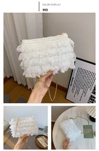 Détail du sac plissé en maille blanc cassé avec chaîne dorée et texture douce