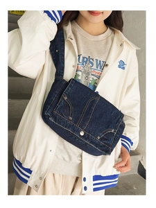 Dark blue denim crossbody bag shown on model highlighting the casual flap and metal buckles