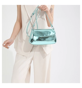 Detail of glossy metallic mint green flap bag with reflective finish and thin strap