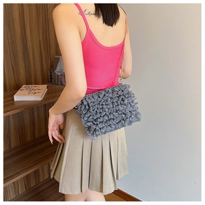 Détail du sac à bandoulière gris à froufrous en mesh avec fine bandoulière dorée