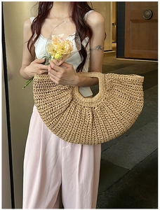 Detailed close-up of the woven straw texture and round handle on the bohemian tote bag