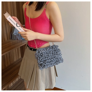 Gray pleated cloud bag featuring a delicate gold chain strap on a fashion model