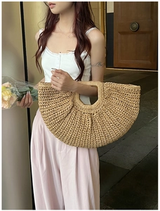 Detail view of a large woven straw handbag showing the natural plant fiber texture
