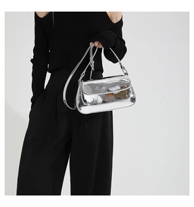 Close-up of a silver metallic crossbody bag with mirror-finish and sleek shoulder strap