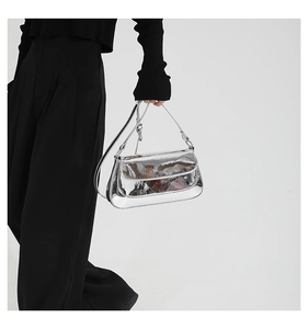 Detail showing sleek silver mirror finish surface and minimalist metal buckle of the bag