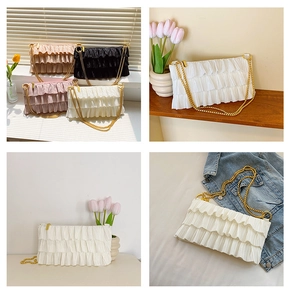 Detailed view of layered pleated fabric textures and gold chain straps on stylish shoulder bags