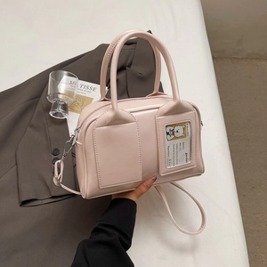 Light pink leather Boston bag with front pockets on a vintage lifestyle background