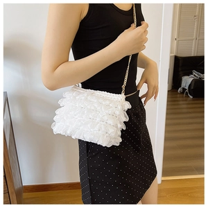Detail of white mesh ruffle crossbody bag with a delicate gold chain shoulder strap