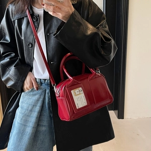 Red glossy patent leather Boston bag with double handles and shoulder strap