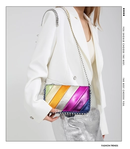 Close-up of rainbow metallic crossbody bag with silver chain strap on fashion model