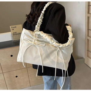 Detail van witte tote tas met strik en geplooide schouderbanden voor casual mode