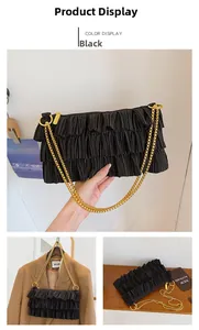 Detail of pleated black shoulder bag featuring chunky gold chain and tiered ruffles