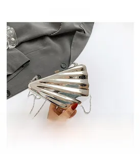 Detail view of the silver shell-shaped evening bag with metallic finish and chain strap