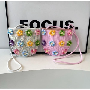 Detail of handmade crochet crossbody bag with 3D floral accents and woven strap