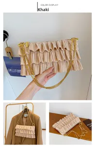 Detailed view of khaki ruffled shoulder bag with tiered pleats and gold chain strap