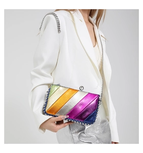 Detail of colorful metallic textured clutch with silver studs and chain strap on white suit