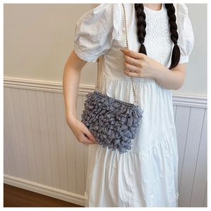 Détail du sac nuage en maille grise avec bandoulière en chaîne dorée pour femme