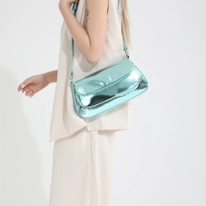 Glossy mirror blue crossbody shoulder bag with sleek metallic finish on model