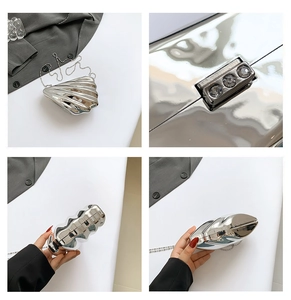 Macro details of silver seashell evening clutch with rhinestone clasp and chain strap