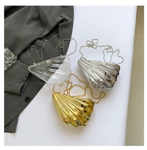 Detailed view of three acrylic shell-shaped evening clutch bags with metallic chain straps