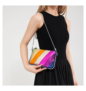 Colorful striped crossbody bag with silver ball trim and chain strap on a black outfit