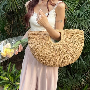 Handcrafted semicircular straw handbag with round handle for beach and resort style