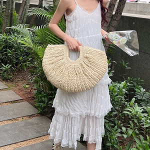 Chic semi-circular hand-woven straw bag in cream white for beach vacations