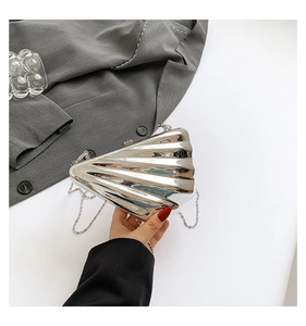 Macro shot of silver shell-shaped metallic crossbody bag with delicate chain strap