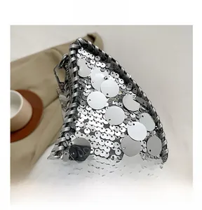 Détails macro des paillettes argentées et des bords tressés sur ce sac lune tendance