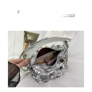 Detail view of silver sequin handbag interior showing large capacity and zipper pocket
