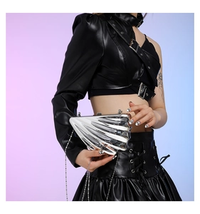 Detail of silver shell-shaped metallic crossbody bag with textured finish and chain strap