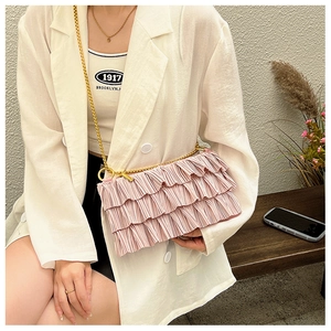 Detail of pink tiered ruffle crossbody bag with a delicate gold chain shoulder strap