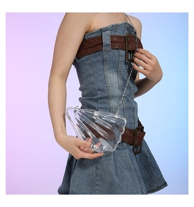 Detailed view of a transparent shell-shaped acrylic clutch bag with a silver chain strap